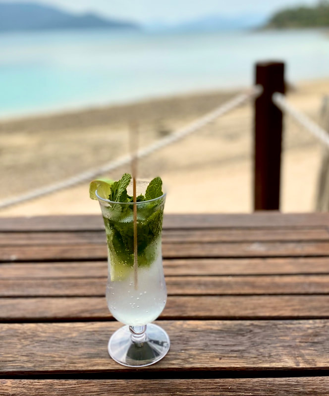 Mojito cocktail on table in front of beach