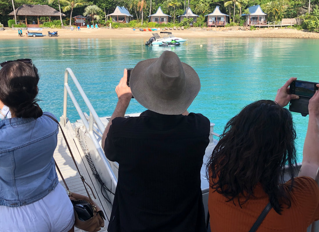 Excited tourists taking photos of beautiful island resort